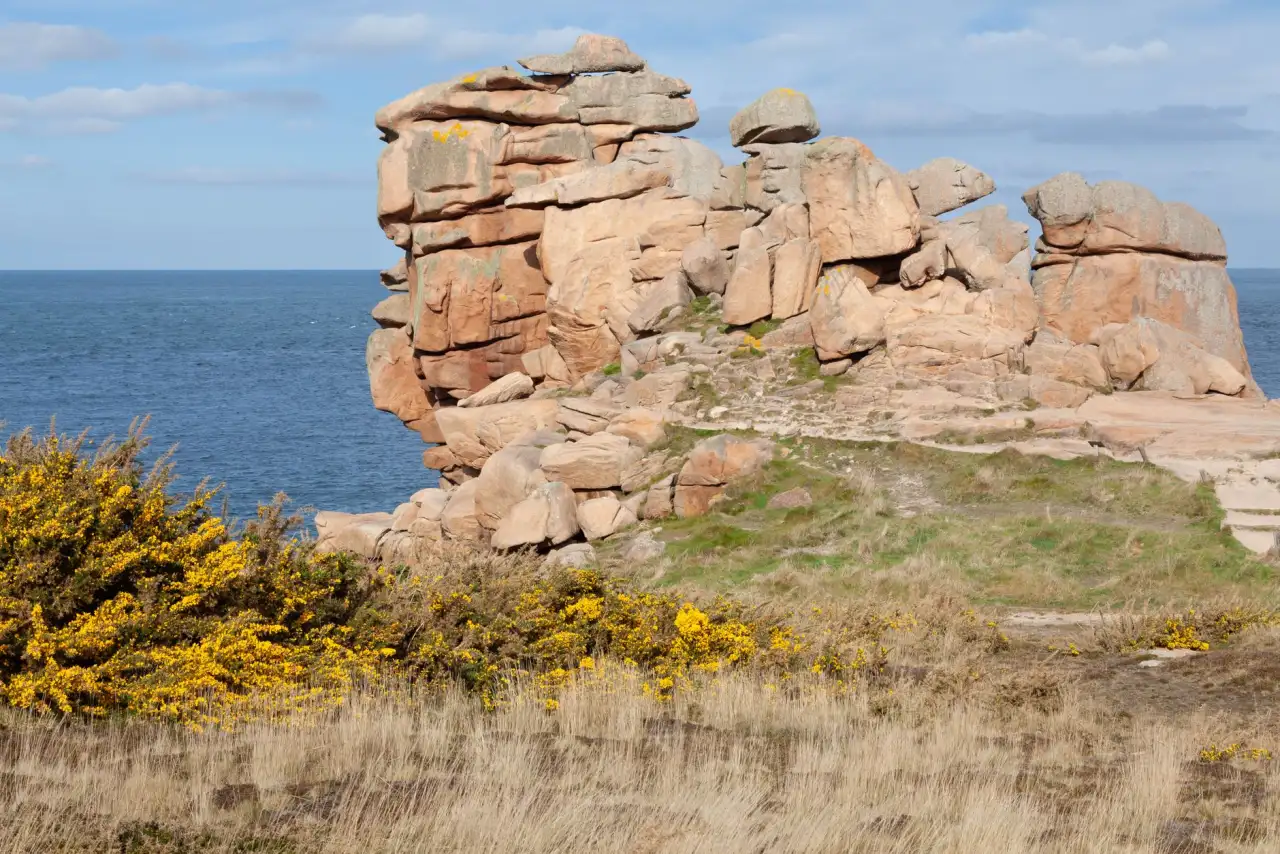 Côte rocheuse de granit en Bretagne sous un ciel dégagé