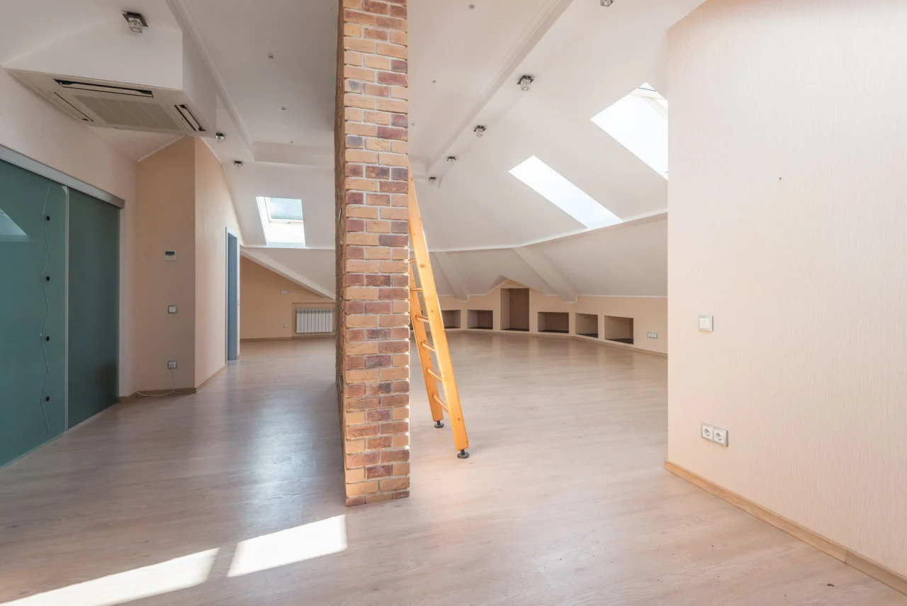 Pièce sous les toits avec plancher bois en cours de rénovation